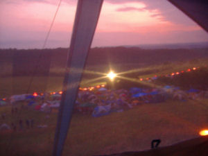 The line of incoming campers Thursday night from the tent window.  We were quite pleased with ourselves that we had an admirable campsite set up with torches burning to welcome the new arrivals!  Actually we discussed several times how much the folks in cars were hating us!  